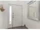 Bright entryway with a white door, sidelight window, gray flooring, and a decorative mirror at 339 Magical Way, Kissimmee, FL 34744