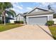 Charming single-story home with a manicured lawn, two-car garage, and freshly painted exterior at 339 Magical Way, Kissimmee, FL 34744