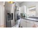 Stainless steel refrigerator complemented by white cabinets and neutral countertops at 339 Magical Way, Kissimmee, FL 34744