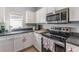 Bright kitchen features white cabinetry, stainless steel appliances, and neutral countertops at 339 Magical Way, Kissimmee, FL 34744
