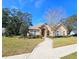 Beautiful single-story home showcasing a curved walkway, mature trees, and well-maintained lawn at 5685 Lake Victoria Dr, Lakeland, FL 33813