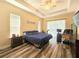 Bright main bedroom with a trey ceiling, a ceiling fan, and a sliding glass door leading to the outdoors at 5685 Lake Victoria Dr, Lakeland, FL 33813