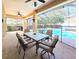 Inviting covered patio with a ceiling fan, dining set, and screened-in pool view at 5685 Lake Victoria Dr, Lakeland, FL 33813