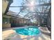 Outdoor pool area with screened enclosure, deck, mature tree, and fenced perimeter at 5685 Lake Victoria Dr, Lakeland, FL 33813