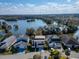 Aerial view of homes nestled along a lake, offering scenic waterfront living and community charm at 616 Peninsular Dr, Lakeland, FL 33813
