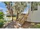 Home's backyard with wooden stairs leading to a deck with water views at 616 Peninsular Dr, Lakeland, FL 33813