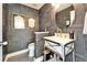 Stylish powder room with a modern vanity, patterned walls, and gold fixtures at 616 Peninsular Dr, Lakeland, FL 33813