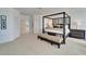 Spacious main bedroom featuring a four-poster bed, neutral carpet, and a matching bench and dresser at 616 Peninsular Dr, Lakeland, FL 33813