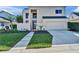 Contemporary home featuring a well-manicured lawn, stylish front door, and an attached two car garage at 616 Peninsular Dr, Lakeland, FL 33813