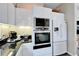 Bright kitchen featuring modern appliances, white cabinetry, and black countertops, offering a clean and functional space at 616 Peninsular Dr, Lakeland, FL 33813