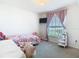 Cozy bedroom with a floral-themed bed, pink accents, and natural light at 456 Hilltop Dr, Lake Wales, FL 33853