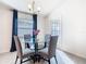 Bright dining area features a glass table, modern chandelier, and access to the backyard at 456 Hilltop Dr, Lake Wales, FL 33853