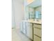 Bathroom featuring double sinks, ample storage space, and glass enclosed shower at 648 Bloom Ter, Davenport, FL 33836