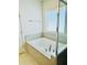 Soaking tub with tile surround, offering a serene space for relaxation and comfort at 648 Bloom Ter, Davenport, FL 33836