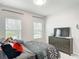 Cozy bedroom with a patterned bedspread, a dresser with a television, and ample natural light at 648 Bloom Ter, Davenport, FL 33836