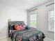 Comfortable bedroom featuring a patterned bedspread, bright windows, and neutral-toned walls at 648 Bloom Ter, Davenport, FL 33836