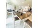 Open-concept dining area with seating for six is adjacent to the modern kitchen and living room at 648 Bloom Ter, Davenport, FL 33836