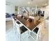 Open-concept floor plan showcases a dining table, adjacent to kitchen with stainless steel appliances and granite countertops at 648 Bloom Ter, Davenport, FL 33836