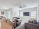 Bright living room featuring ample seating, modern ceiling fan, and sliding glass doors at 648 Bloom Ter, Davenport, FL 33836