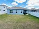Green backyard and blue house. Blue sky in the background at 648 Bloom Ter, Davenport, FL 33836