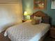 Cozy bedroom featuring a bed with a decorative white coverlet, wicker headboard and a light-aqua colored wall at 705 Gran Bahama Blvd # 705, Davenport, FL 33897