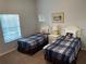 Bedroom with two beds that have blue plaid covers, a nightstand and a window with blinds at 705 Gran Bahama Blvd # 705, Davenport, FL 33897