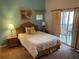 Bedroom features a comfortable bed, bedside tables with lamps, and sliding glass doors to the patio at 705 Gran Bahama Blvd # 705, Davenport, FL 33897