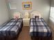 Bedroom with two beds that have blue plaid covers, a nightstand and a window with blinds at 705 Gran Bahama Blvd # 705, Davenport, FL 33897