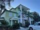 Exterior of a 3-story building with green wood siding, white railings and stairs, and well-manicured landscaping at 705 Gran Bahama Blvd # 705, Davenport, FL 33897