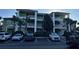 Three-story building with green facade, white railings, palm trees, and a parking lot in front at 705 Gran Bahama Blvd # 705, Davenport, FL 33897