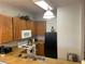 Kitchen features wooden cabinets, white appliances, and essential kitchenware for easy meal preparation at 705 Gran Bahama Blvd # 705, Davenport, FL 33897