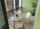 Screened in patio with an outdoor table and four chairs overlooking the manicured green grounds and community at 705 Gran Bahama Blvd # 705, Davenport, FL 33897