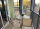 Screened in patio with an outdoor table and four chairs overlooking the manicured green grounds and community at 705 Gran Bahama Blvd # 705, Davenport, FL 33897