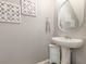 Modern powder room with a pedestal sink, decorative mirror, and matching wall decor at 380 Arbor Lakes Dr, Davenport, FL 33896