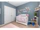 Sweet Bedroom featuring a floral crib design, plush rug, and ample closet space at 380 Arbor Lakes Dr, Davenport, FL 33896