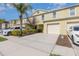Townhome exterior with attached one-car garage and a well-manicured lawn at 380 Arbor Lakes Dr, Davenport, FL 33896