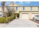 Two-story townhome with one-car garage, well-kept lawn, and yellow siding at 380 Arbor Lakes Dr, Davenport, FL 33896