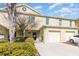 Yellow townhome exterior featuring a one car garage, lawn, and walkway to the front door at 380 Arbor Lakes Dr, Davenport, FL 33896