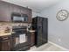 Well-lit kitchen features sleek black appliances, a decorative clock, and stylish mosaic backsplash at 380 Arbor Lakes Dr, Davenport, FL 33896
