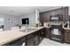 Well-equipped kitchen with dark cabinetry, black appliances, and a stone countertop at 380 Arbor Lakes Dr, Davenport, FL 33896