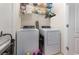Efficient laundry room equipped with a washer, dryer, and wire shelving for extra storage at 380 Arbor Lakes Dr, Davenport, FL 33896