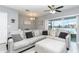 Comfortable living room with gray sectional couch, ceiling fan, and sliding glass door to the backyard at 380 Arbor Lakes Dr, Davenport, FL 33896