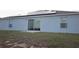 Home's backyard with patio, featuring solar panels and a sliding glass door at 512 Central Ridge Ln, Frostproof, FL 33843
