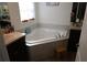 Bathroom with garden tub, wood-style floor, and tiled walls at 512 Central Ridge Ln, Frostproof, FL 33843