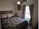Comfortable bedroom with a patterned comforter, ceiling fan, and window at 512 Central Ridge Ln, Frostproof, FL 33843