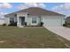 Beautiful single-Gathering home features a two-car garage, manicured lawn, and blue front door at 512 Central Ridge Ln, Frostproof, FL 33843
