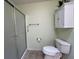 Bathroom featuring a toilet, white storage cabinet, and a shower with sliding doors at 992 Davit Pl, The Villages, FL 32162