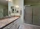 Bathroom featuring a granite countertop, mirror, and glass-enclosed shower at 992 Davit Pl, The Villages, FL 32162