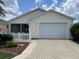 Charming home featuring a patterned driveway, an attached two-car garage, and a well manicured yard at 992 Davit Pl, The Villages, FL 32162