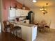 Bright eat-in kitchen featuring white cabinetry, granite countertops, stainless steel appliances and modern light fixtures at 992 Davit Pl, The Villages, FL 32162